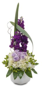 violet colored stock with lavender roses hydrangea and greens in vase
