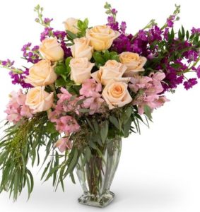 lavish arrangement of Roses, Alstroemeria, Scabiosa, Italian Ruscus and premium greens is designed in a full, sweeping design and comes delivered in a beautiful glass vase. 